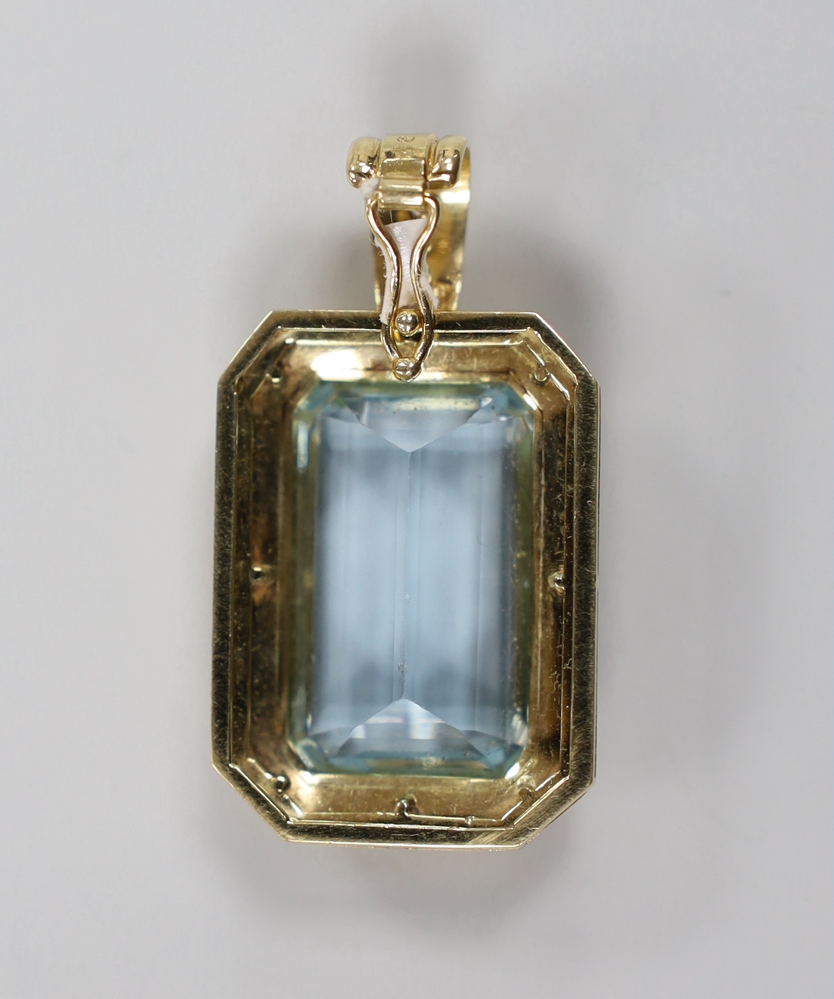 A modern 14ct gold and single stone emerald cut aquamarine set octagonal pendant, with six stone diamond chip set bale, overall 41mm, gross weight 14.6 grams.